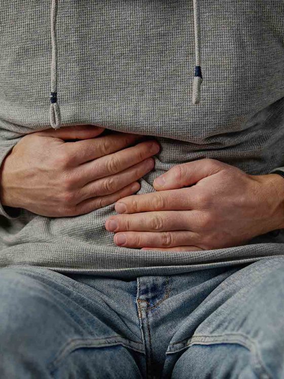 man clutching stomach dues to CHS symptoms