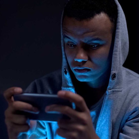 young teen male on phone at night