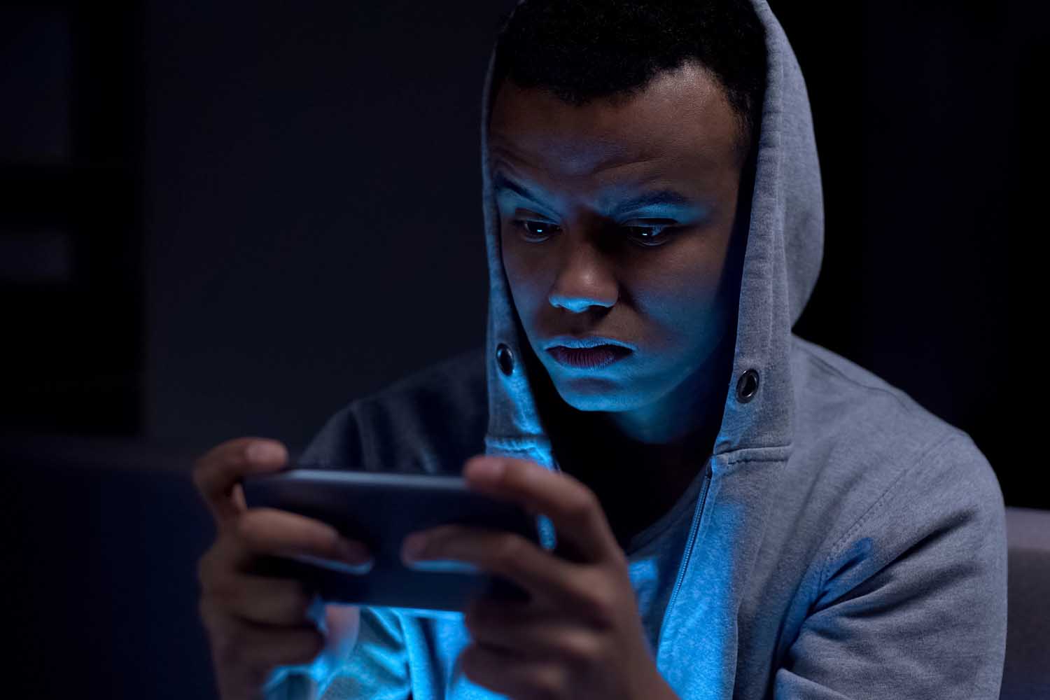 young teen male on phone at night