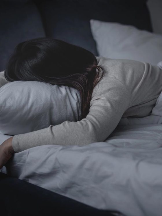 woman trying to sleep while dealing with chronic health issue